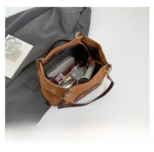Vista interior que muestra la gran capacidad y compartimentos del bolso tote marrón