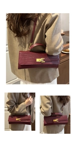 Detailed view of crocodile pattern leather texture and golden metal twist lock on the handbag