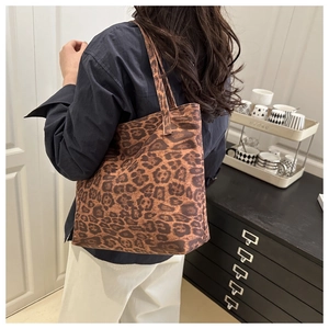 Detail view of large leopard print canvas tote bag on model for casual commuting