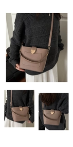 Détail du sac bandoulière taupe avec boucle dorée en forme de cœur et logo imprimé