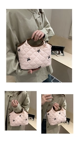 Detail showing pink quilted handbag with black bow embroidery and contrast handles