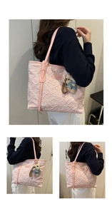 Detail of pink floral embroidered tote bag with bear charm and leather handles