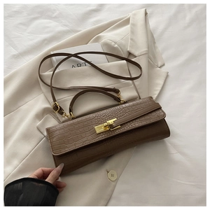 Macro detail of brown crocodile texture leather bag with vintage gold metal buckle
