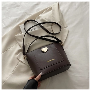 Détail du sac seau en cuir marron foncé avec fermoir doré en forme de cœur élégant
