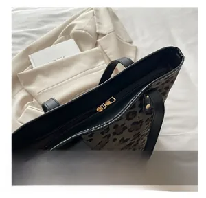 Detail view of smooth golden zipper and leopard print texture on this fashion tote bag
