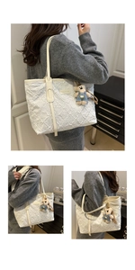 Close-up of white tote bag featuring embossed texture and a cute plush bear charm
