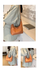 Detail of orange lychee grain PU leather hobo bag with knotted shoulder strap and ring