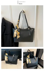 Detail of black tote bag with white contrast stitching and yellow decorative silk scarf
