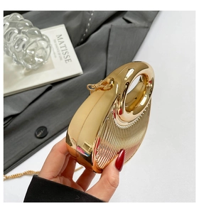 Detail of gold metallic evening bag showing vertical textures and round top handle