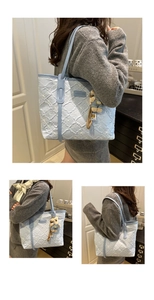 Detailed quilted light blue tote bag featuring floral embroidery and a small bear charm