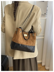 Quilted tote bag detail featuring dual-texture leather, chain strap, and gold twist lock