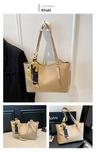 Detail of khaki bucket bag with decorative printed silk scarf tied on the handle