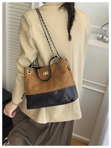 Detail of color-block quilted shoulder bag with gold chain strap and metal turn-lock