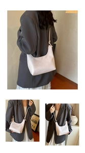 Close-up of cream leather shoulder bag showing the pebble texture and adjustable strap