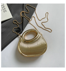 Detailed view of the wavy textured golden metallic evening bag with sleek chain strap