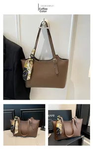 Macro shot of brown faux leather tote bag featuring contrast stitching and floral silk scarf