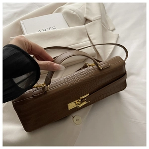 Detailed texture of brown crocodile pattern leather with gold metal twist lock buckle