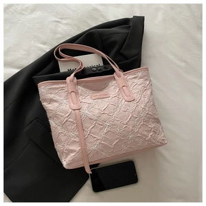 Detail of light pink tote bag with floral embroidery and Tidal Dryness leather logo