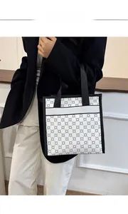 Detail of printed canvas tote bag featuring geometric patterns and durable black straps