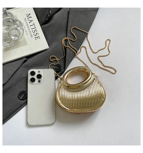 Top view of a gold metallic semi-circle evening bag with elegant vertical stripes and chain