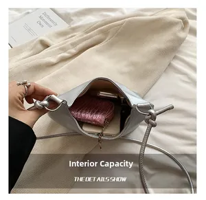 Detail view of silver crossbody bag interior showing large capacity for phone and wallet