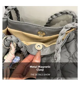 Macro detail of silver magnetic hardware clasp on a grey quilted tote bag with lining