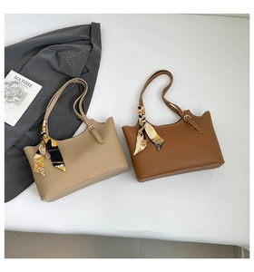 Detail of minimalist tote bags with scalloped edges, metal buckles and floral scarves