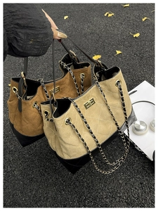 Detail of contrast stitch textures and gold chain strap on stylish shoulder bags