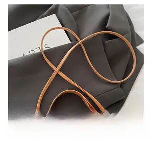 Detail view of brown faux leather crossbody bag shoulder strap and stitching craft