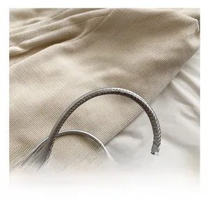Close-up of silver woven texture handle on a fashion crossbody bag for women