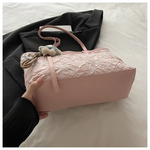 Pink tote bag detail with floral embroidery, pleated texture, and plush bear charm