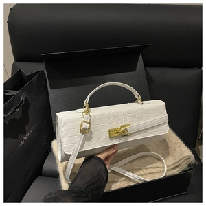 Detail of white crocodile texture handbag with gold twist lock on soft knit fabric