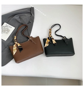Detail of minimalist leather tote bags with silk scarves and white contrast stitching