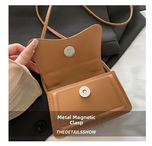Macro detail of brown leather handbag featuring a secure magnetic snap closure design