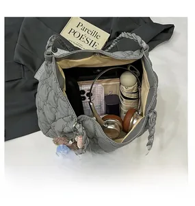 Macro shot of spacious interior in grey quilted tote bag with daily essentials organized