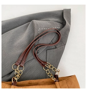 Détail du sac cabas en velours côtelé marron avec maillons dorés et anses en cuir synthétique