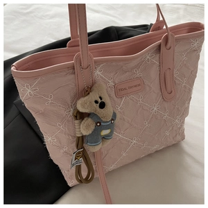 Detailed pink tote bag with floral embroidery and cute bear plush charm accessory