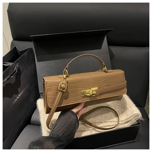 Detail of brown crocodile pattern leather bag with golden turn-lock and elegant texture
