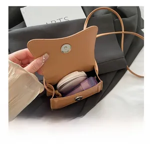Internal view of brown faux leather mini bag showing storage for makeup and magnetic clasp
