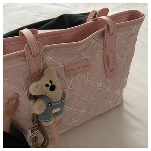 Pink pleated tote bag with floral embroidery and a cute teddy bear charm detail