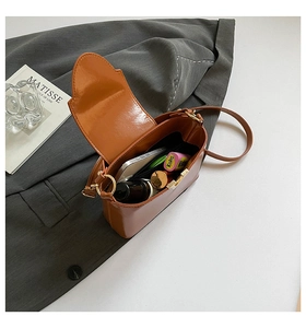 Interior view of brown leather crossbody bag showing space for phone and makeup accessories