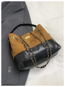 Detail of two-tone shoulder bag with brown suede, black quilted leather and gold lock