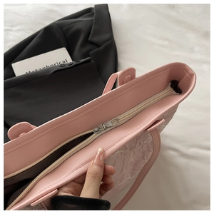 Detail view of pink lace tote bag showing floral embroidery and silver metal zipper