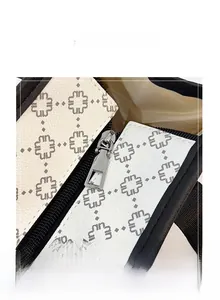 Detailed view of silver metal zipper and geometric flower pattern on white tote bag