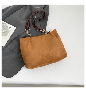Détail du sac fourre-tout en daim marron avec bandoulière élégante en chaîne et cuir