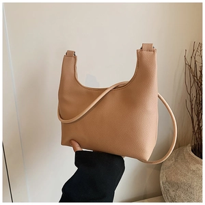 Detail of khaki textured leather hobo bag with a minimalist half-moon shape design