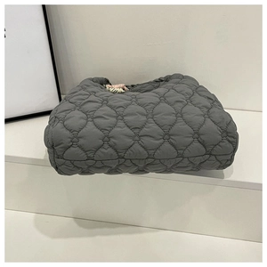 Detail of dark grey tote bag featuring unique heart-shaped quilted pattern and nylon texture