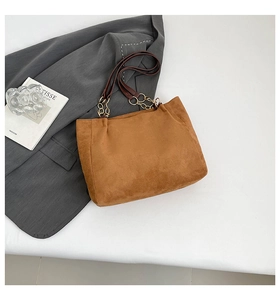 Vue détaillée du sac cabas en daim marron avec bandoulière en cuir et chaîne dorée