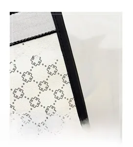 Detailed close-up of geometric pattern print and precision stitching on the leather handbag