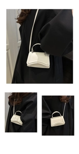 Macro detail of micro white leather handbag showing handle attachment and matte finish texture